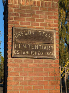 Oregon State Penitentiary sign on a brick pillar